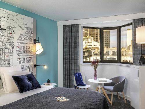 a hotel room with a bed and a table and a window at Hôtel Mercure Paris Centre Gare Montparnasse in Paris