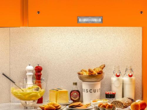 a counter top with bread and a bowl of food at Hôtel Mercure Paris Centre Gare Montparnasse in Paris