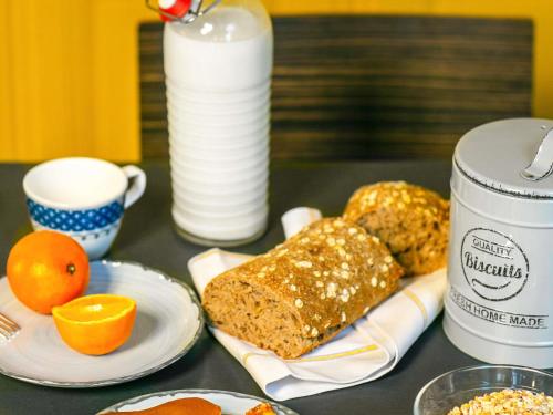 a table topped with plates of bread and a cup of milk at Hôtel Mercure Paris Centre Gare Montparnasse in Paris