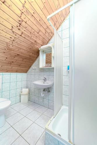 a bathroom with a shower and a sink and a tub at Tranzit Vendégház B in Ráckeve