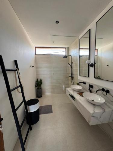 a bathroom with two sinks and a large mirror at Elements Villa B1 - Rooftop, Pool & 5-Min to Beach in Bingin Beach