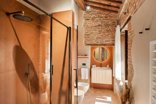ein Bad mit einer Glasdusche und einer Steinwand in der Unterkunft Villa Antico Tabaccaio - Luxury Farmhouse in Umbrian Countryside in Panicale