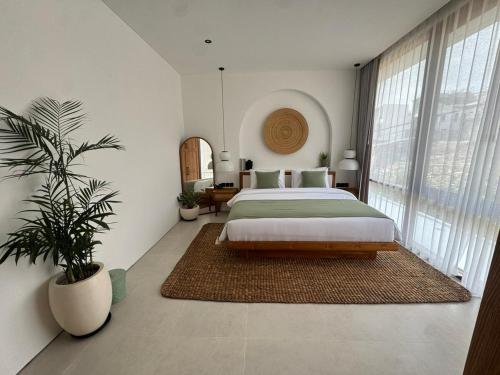 a bedroom with a large bed and a potted plant at Elements Villa B1 - Rooftop, Pool & 5-Min to Beach in Bingin Beach