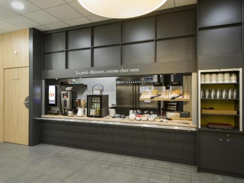 a restaurant with a counter with aasteryasteryasteryasteryasteryasteryasteryasteryastery at B&B HOTEL Lyon Ouest Tassin in Tassin-la-Demi-Lune