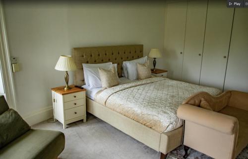 a bedroom with a bed and a chair and a couch at Denham Mount in Buckinghamshire