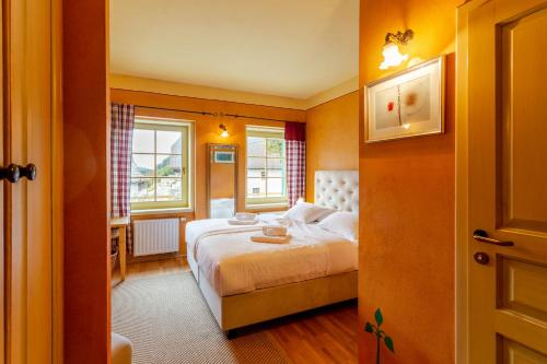 una camera da letto con un letto e due finestre di Pod Gora Boutique Hotel a Kranjska Gora