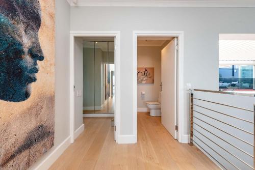 Villa Infinity Plettenberg Luxury Ocean View في بليتنبيرغ باي: حمام به لوحة على الحائط