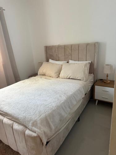 a large bed in a bedroom with a night stand at This home is paradise in Boca Chica