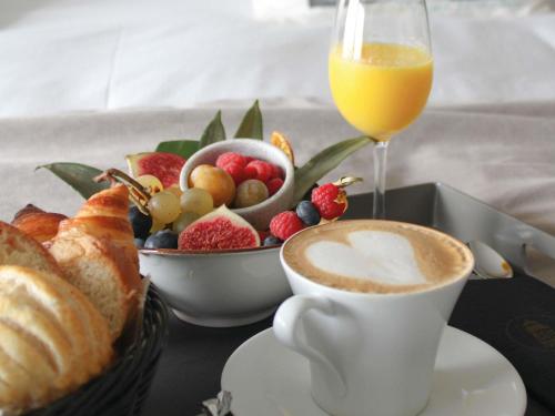ein Tablett mit einer Tasse Kaffee und einer Schale Obst in der Unterkunft Côte Ouest Thalasso & Spa Les Sables d'Olonne - MGallery Collection in Les Sables-dʼOlonne