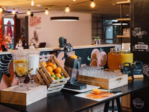 Un mostrador con un montón de frutas y jugos. en Hôtel Mercure Lille Aéroport, en Lesquin