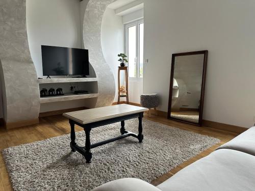 PlanchezにあるLogement Spacieux et Lumineuxのリビングルーム(コーヒーテーブル、鏡付)