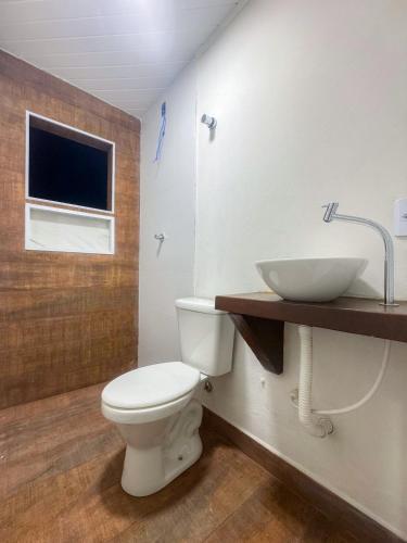 a bathroom with a white toilet and a sink at Aconchego da Lu in Angra dos Reis