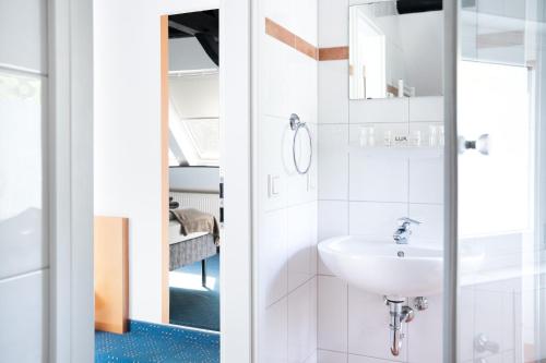 a bathroom with a sink and a mirror at Hotel Das Kemperdick in Erkrath