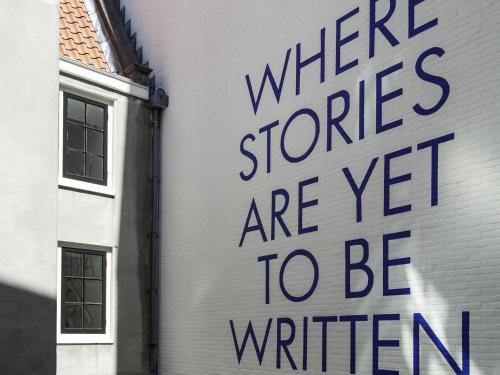 阿姆斯特丹INK Hotel Amsterdam - MGallery Collection的建筑物的侧面标牌,上面写着任何商店都还有待