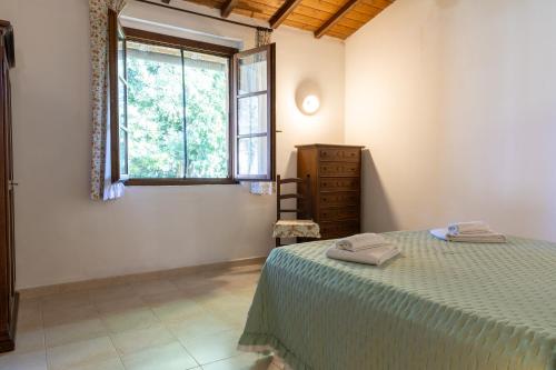a bedroom with a bed and a window at Agriturismo Arcobaleno in Bagno Roselle