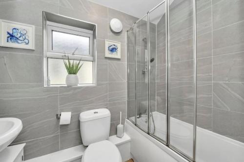 a bathroom with a toilet and a shower and a sink at Wherstead Rd House By Homestyles Hosts Short Lets & Serviced Accommodation Suffolk With Free Parking in Ipswich