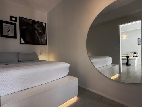Un dormitorio con una cama blanca y un espejo. en AELIA Tinos, en Tinos