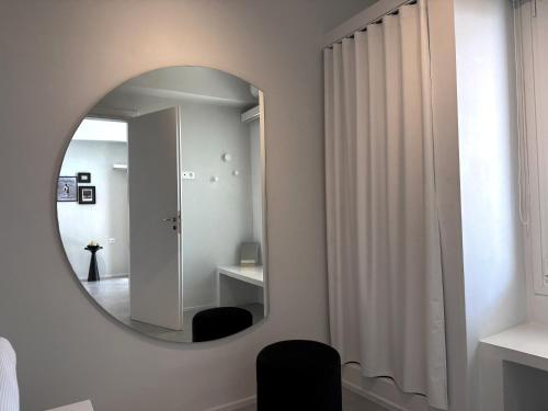 baño con espejo y silla negra en AELIA Tinos, en Tinos