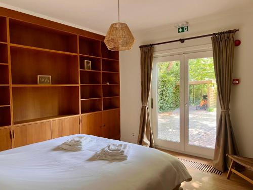 ロンメルにあるVilla Bosrijkのベッドルーム1室(大型ベッド1台、スライド式ガラスドア付)