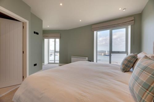 een slaapkamer met een groot bed met een groot raam bij Harbour Heights Seahouses in Seahouses