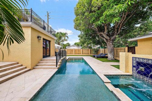ウェストパームビーチにあるPalm Haven - Tropical Chic Home with Pool in Grandview Heightsの家の裏庭にあるプール