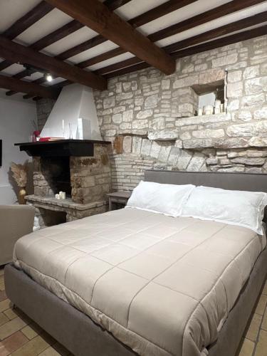 a bedroom with a large bed in a stone wall at Il giardino di Chiara in Assisi