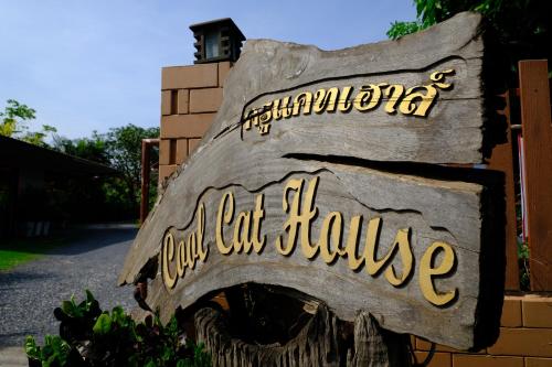 ein Schild für ein Haus, auf dem steht, dass Hunde Menschen fressen in der Unterkunft Cool Cat House ครูแคทเฮาส์ in Ban Khok Ta Yo