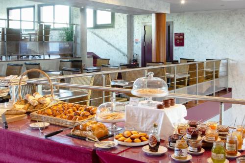 a buffet with bread and pastries on a table at Ile du Gua Suites in Narbonne
