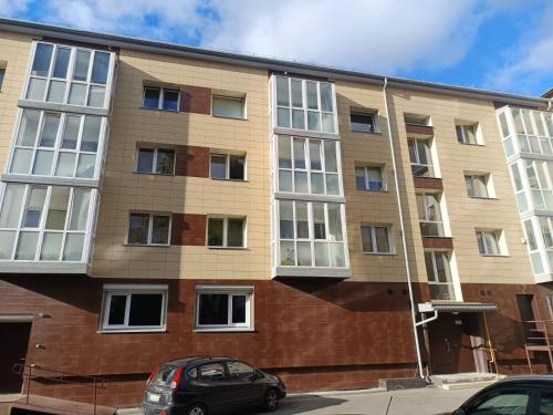 an apartment building with a car parked in front at Draugystės Apartments - Šiauliai Center in Šiauliai