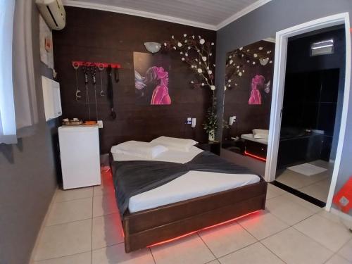 a small bedroom with a bed and a bathroom at Motel A 2 in Criciúma