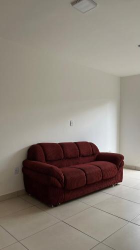 a red couch sitting in a room at Apartamento Aconchego in Luziânia