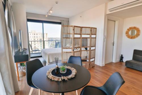 a living room with a table and chairs and a bedroom at Just 100 meters from Shopping del Sol in Asuncion