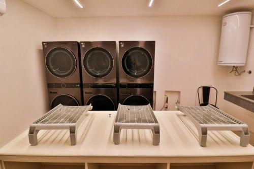 three washing machines in a room with two chairs at Just 100 meters from Shopping del Sol in Asuncion