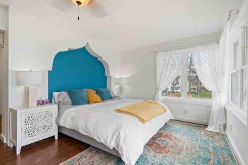 een slaapkamer met een bed met een blauw hoofdeinde en een raam bij Crystal Beach Executive Waterfront Lakehouse in Crystal Beach