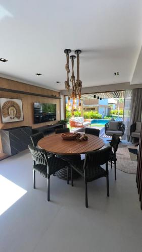 a dining room with a table and chairs at Reserva dos jacarandás praia do forte in Praia do Forte