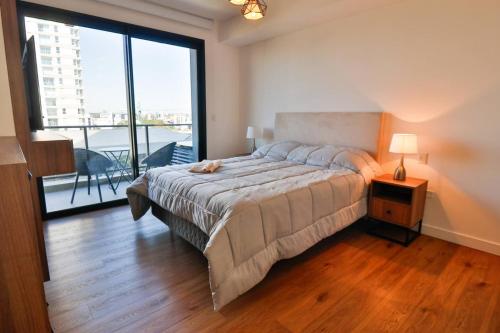 a bedroom with a large bed and a large window at Stylish Retreat Steps from Shopping del Sol in Asuncion