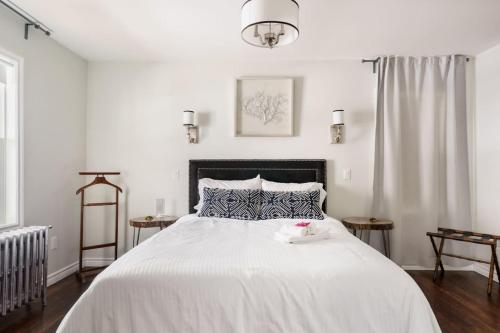 ein Schlafzimmer mit einem großen weißen Bett und einem Tablett darauf in der Unterkunft Wood-Rich Niagara Loft close to Queen Street in Niagara Falls