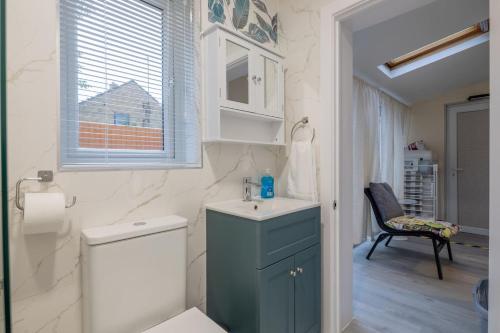 a bathroom with a sink and a toilet and a window at Newly refurbed 3Bed Annexe - With Parking! in Albury