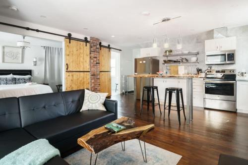 ein Wohnzimmer und eine Küche mit einer Couch und einem Tisch in der Unterkunft Wood-Rich Niagara Loft close to Queen Street in Niagara Falls