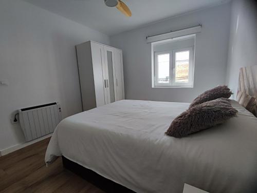 Un dormitorio con una cama con dos almohadas encima. en Puerto Placilla, en El Puerto de Santa María