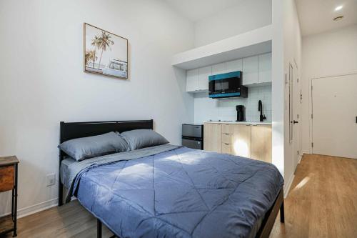 a bedroom with a blue bed and a kitchen at Fabulous Studio with FREE Parking near Montreal Downtown in Montréal