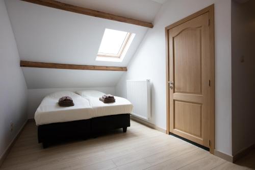 a small bedroom with a bed and a window at Elysian in Ypres