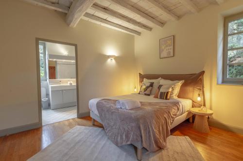 a bedroom with a large bed and a bathroom at Villa Roumentas - 8 pers - Vue vallée & Piscine in Navailles-Angos