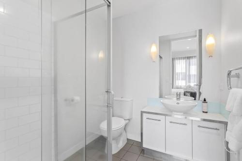 een badkamer met douche, toilet en wastafel bij QV Stays Modern Spacious Multi-Level Townhouse in Auckland