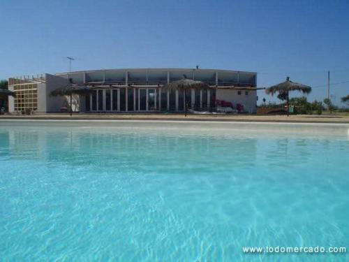 a large pool of blue water in front of a building at Eco good vibrations in Algarrobo