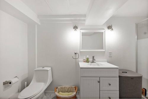 ein weißes Badezimmer mit Toilette und Waschbecken in der Unterkunft Modern Basement Apartment 3 Blocks from Waterfront in Tacoma