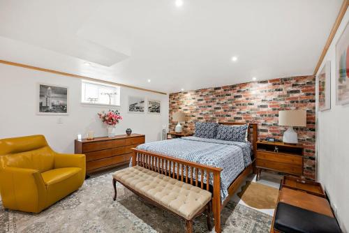 ein Schlafzimmer mit einem Bett und einem gelben Stuhl in der Unterkunft Modern Basement Apartment 3 Blocks from Waterfront in Tacoma