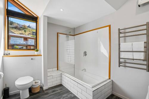 a bathroom with a tub and a toilet and a shower at Lakeview Alpine Villa - Great Views, Close to Town in Frankton Wharf