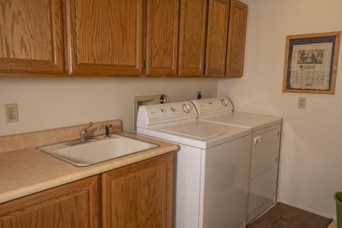eine Küche mit Waschmaschine und Spüle in der Unterkunft 3BR Flagstaff Escape with Deck and Pine Views in East Flagstaff