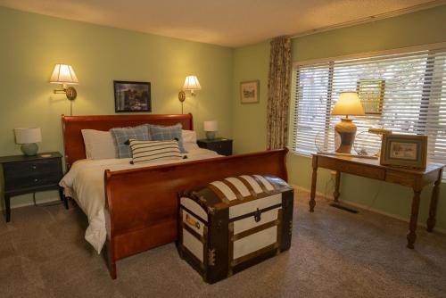 ein Schlafzimmer mit einem Bett und einem Tisch und einem Fenster in der Unterkunft 3BR Flagstaff Escape with Deck and Pine Views in East Flagstaff